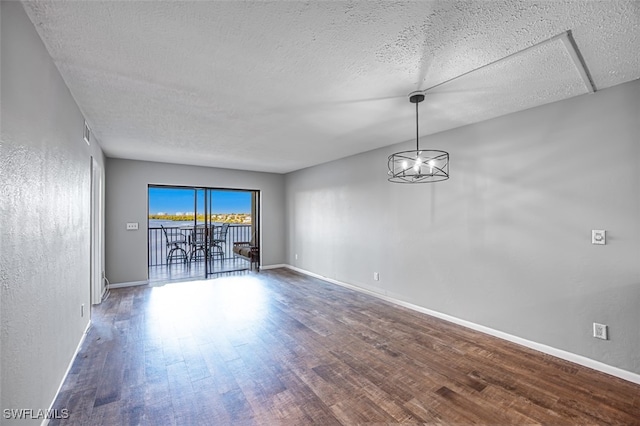 4835 Bonita Beach Rd Unit 408, Bonita Springs, FL 34134 - spare room with baseboards, visible vents, wood finished floors, a textured ceiling, and a notable chandelier