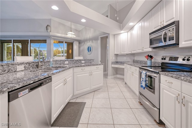 kitchen with stainless steel appliances, light stone counters, sink, hanging light fixtures, and white cabinets