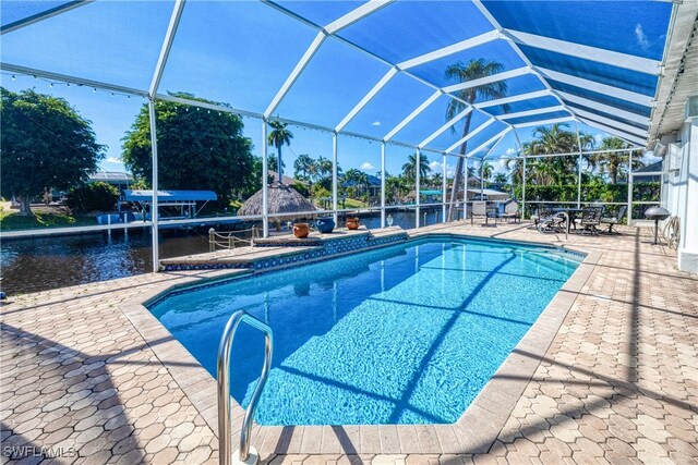 view of pool featuring a water view, a lanai, and a patio