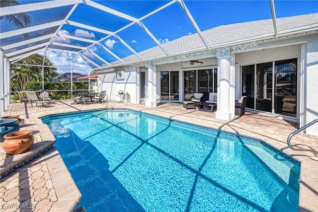 view of swimming pool featuring a lanai, a patio area, and ceiling fan