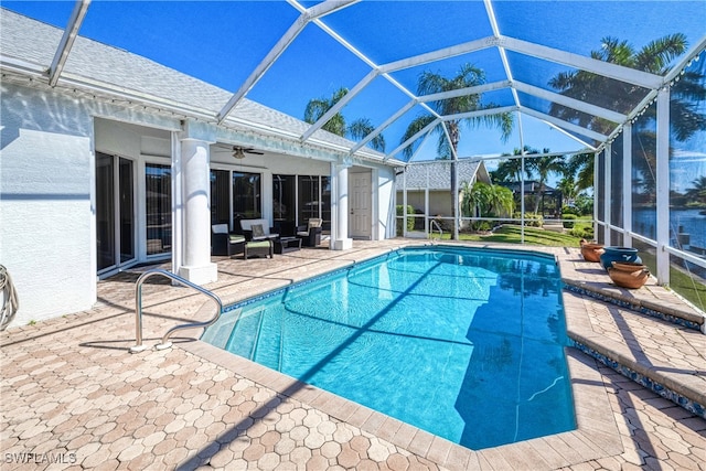 view of pool featuring glass enclosure, ceiling fan, and a patio