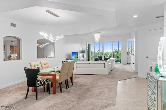 dining area with light colored carpet and an inviting chandelier