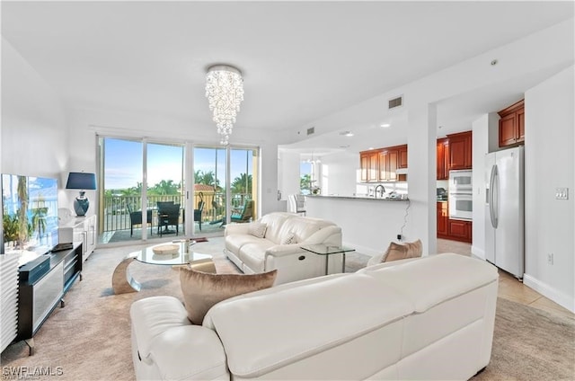 living room featuring light colored carpet and a notable chandelier