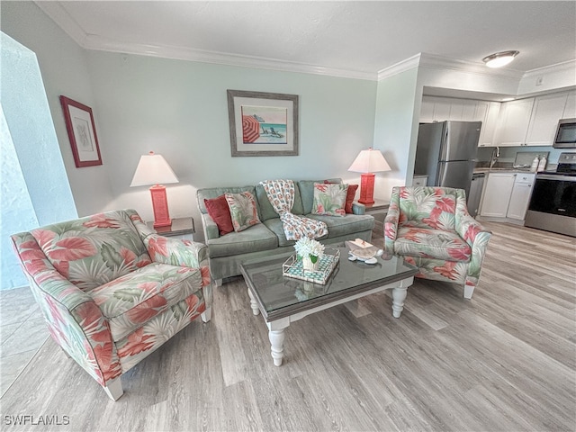 living room with crown molding, sink, and light hardwood / wood-style flooring