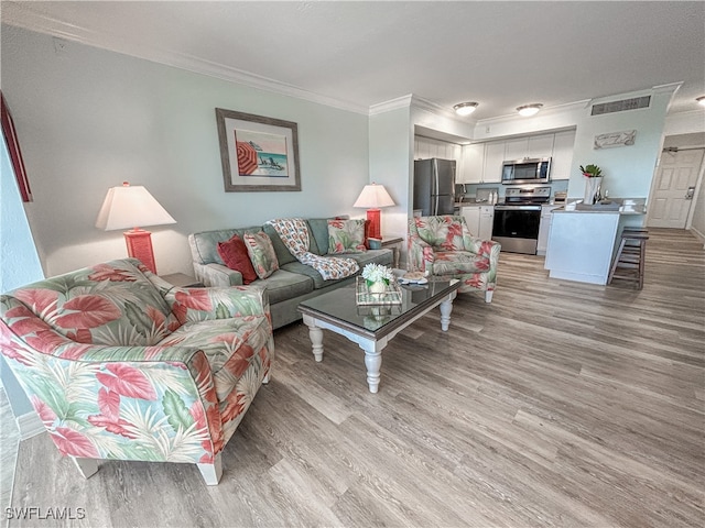 living room with crown molding and light wood-type flooring