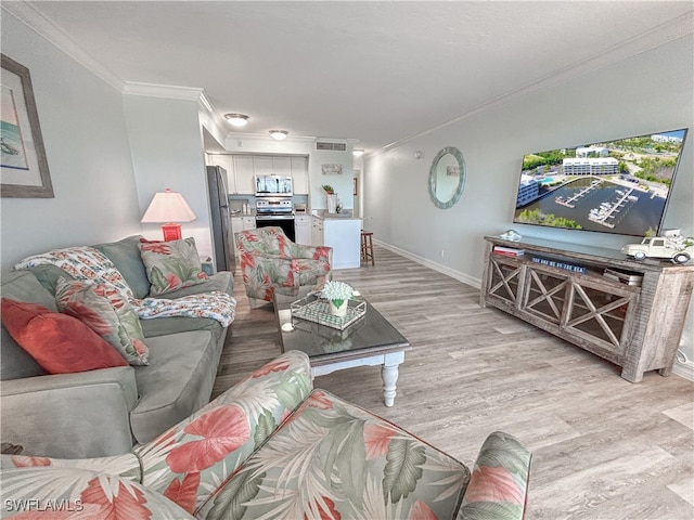 living room with ornamental molding and light hardwood / wood-style floors