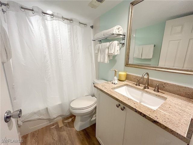 full bathroom with vanity, toilet, wood-type flooring, and shower / tub combo with curtain