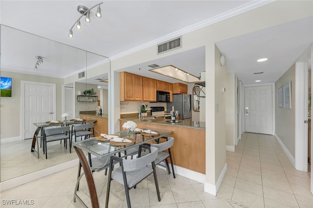 dining area with ornamental molding, sink, and light tile patterned flooring