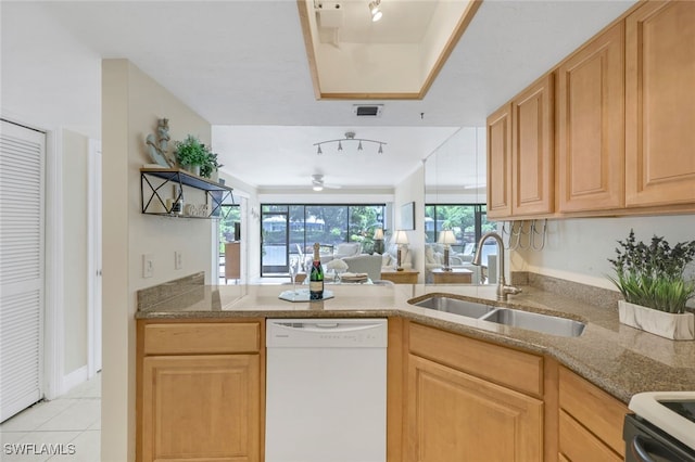 kitchen with light tile patterned floors, white dishwasher, light stone countertops, sink, and kitchen peninsula