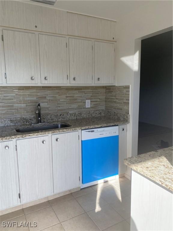 kitchen featuring light brown cabinets, dishwasher, decorative backsplash, and sink