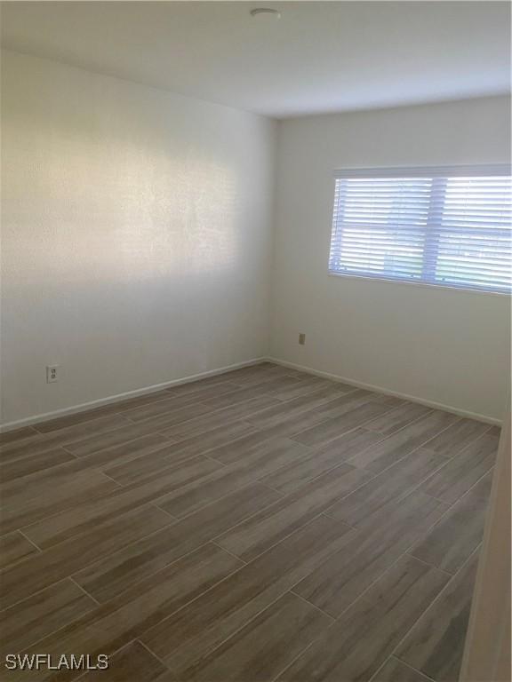 unfurnished room featuring dark hardwood / wood-style floors