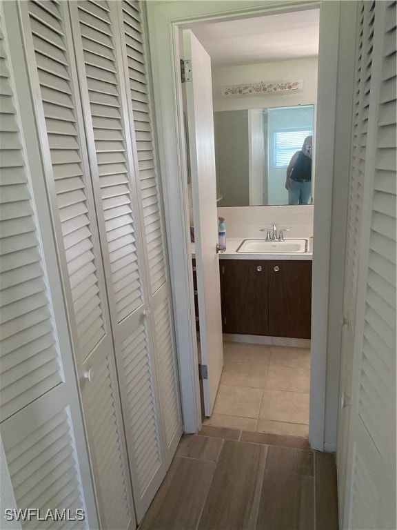 corridor featuring tile patterned floors and sink