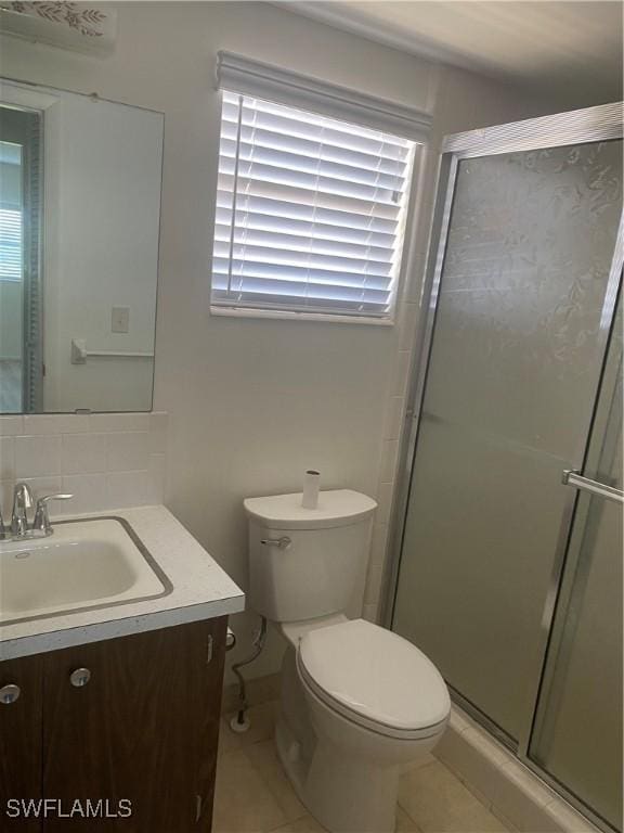 bathroom featuring toilet, decorative backsplash, a shower stall, vanity, and tile patterned flooring