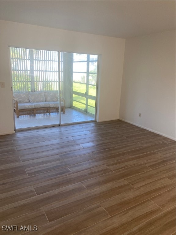 unfurnished room with dark wood-type flooring