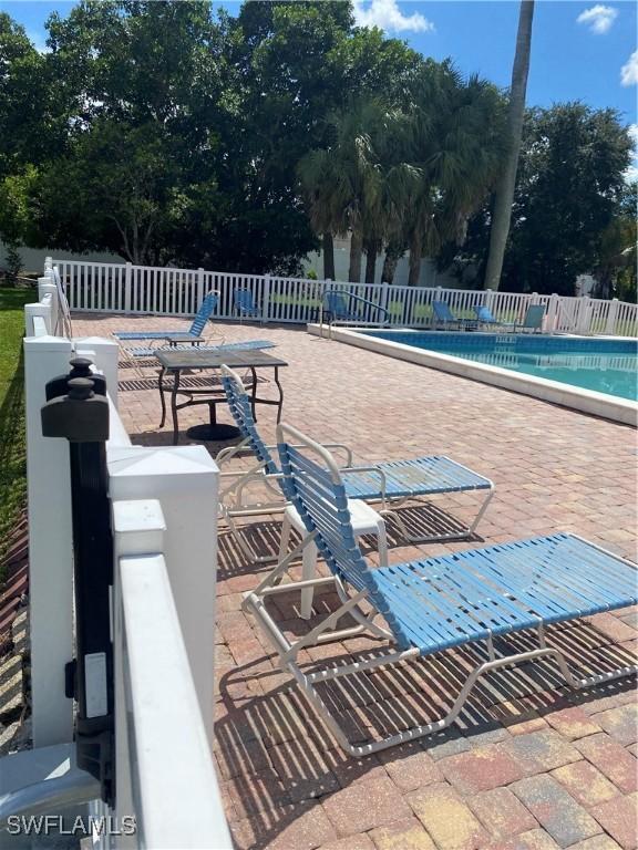 pool with a patio area and fence