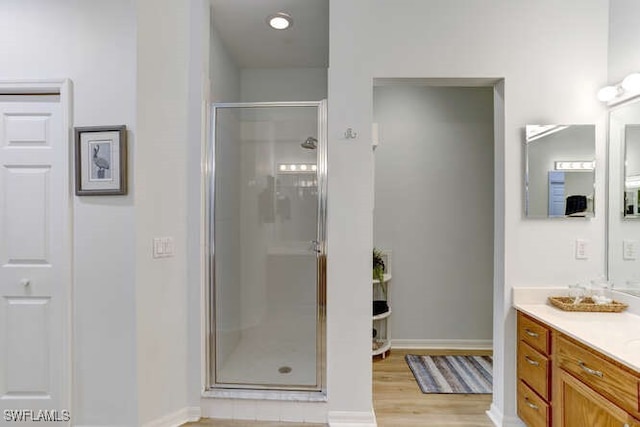 bathroom featuring a shower with door, hardwood / wood-style flooring, and vanity