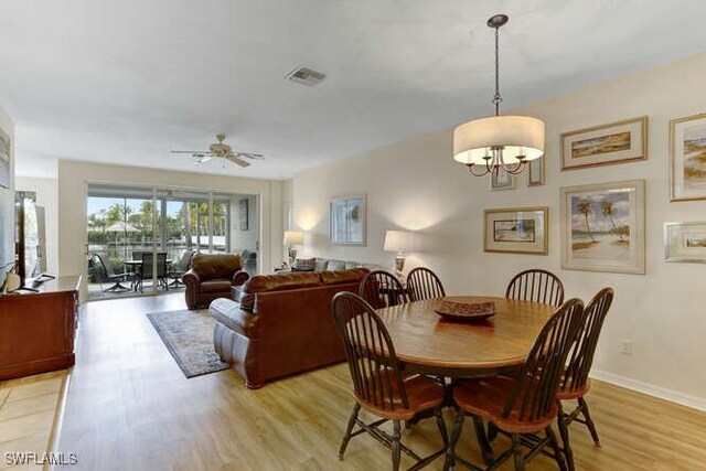 dining space featuring ceiling fan with notable chandelier and light wood-type flooring