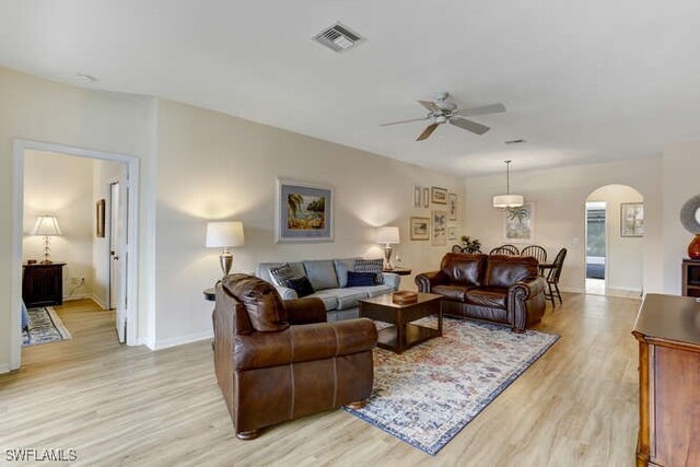 living room with light hardwood / wood-style flooring and ceiling fan