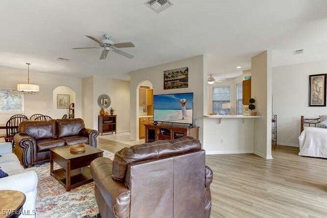 living room with light hardwood / wood-style flooring and ceiling fan