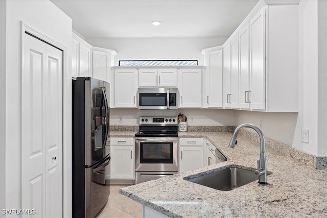 kitchen with stainless steel appliances, white cabinetry, and sink