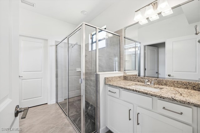 bathroom with vanity, an enclosed shower, and tile patterned floors