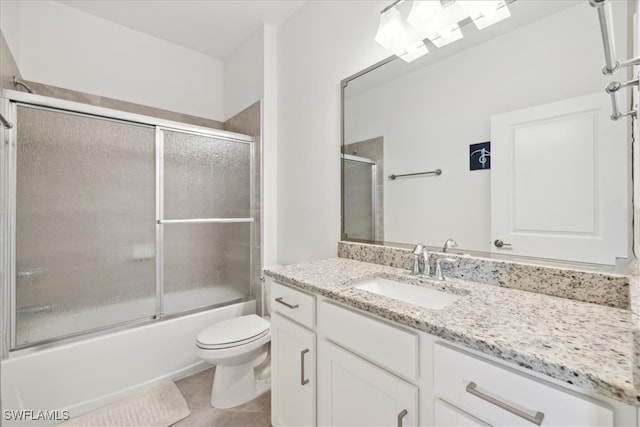 full bathroom with tile patterned flooring, vanity, toilet, and bath / shower combo with glass door