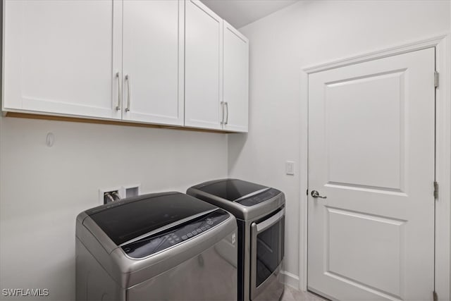 washroom featuring cabinets and washing machine and dryer