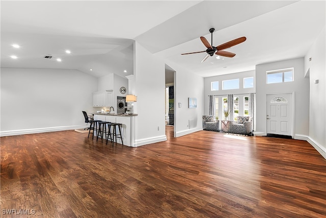 unfurnished living room with high vaulted ceiling, ceiling fan, and dark wood-type flooring