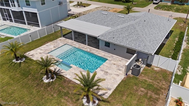 view of pool featuring a patio, central AC unit, a fenced backyard, and a pool with connected hot tub