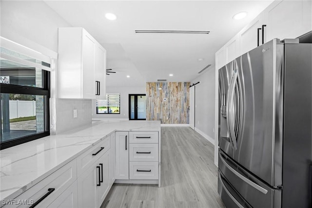 kitchen with a peninsula, white cabinets, and stainless steel fridge with ice dispenser