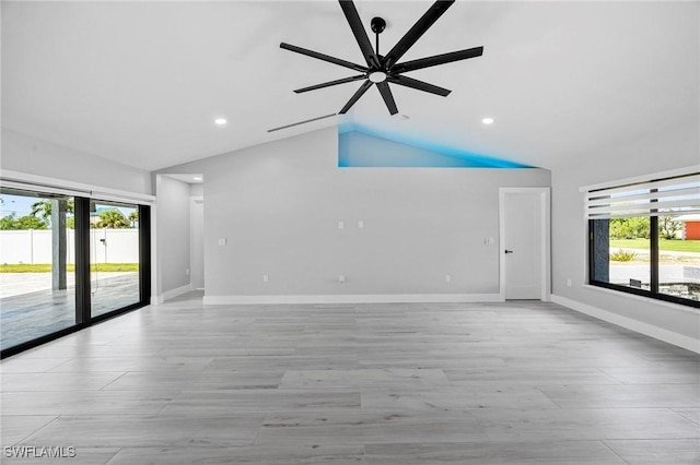 empty room with a healthy amount of sunlight, baseboards, and vaulted ceiling