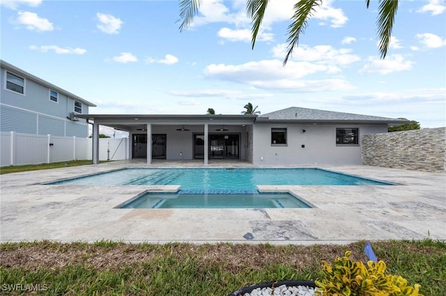 view of pool with a ceiling fan, a pool with connected hot tub, a fenced backyard, and a patio