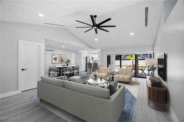 living room with visible vents, light wood-style flooring, ceiling fan, high vaulted ceiling, and baseboards