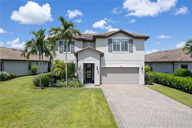 mediterranean / spanish home with a garage and a front lawn