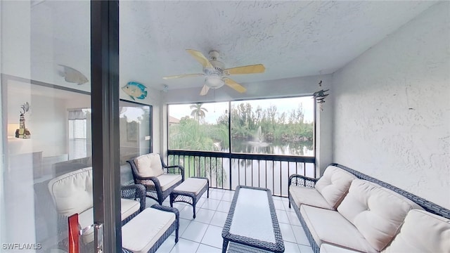 sunroom / solarium with a water view and ceiling fan