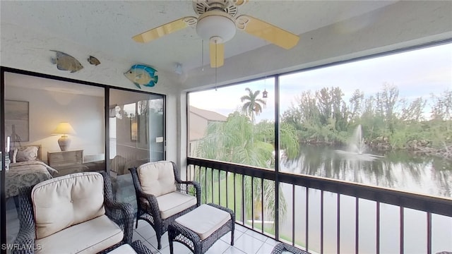 sunroom / solarium with a water view and ceiling fan