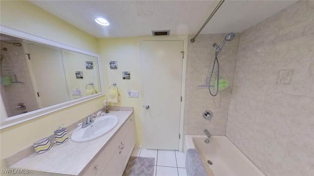 bathroom featuring a textured ceiling, vanity, tile patterned floors, and tiled shower / bath