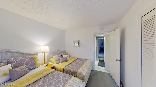 bedroom with tile patterned flooring and a textured ceiling