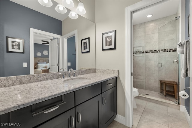 bathroom with ceiling fan, tile patterned flooring, toilet, vanity, and a shower with shower door