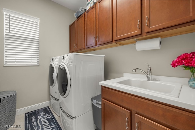 washroom featuring sink, cabinets, and independent washer and dryer