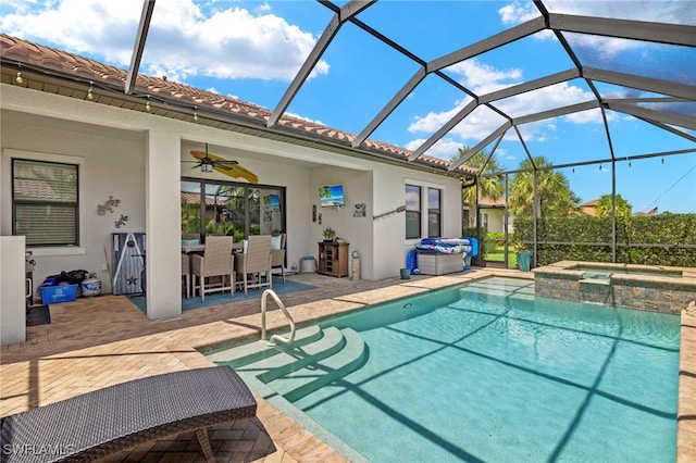 view of swimming pool with ceiling fan, a lanai, exterior bar, an in ground hot tub, and a patio