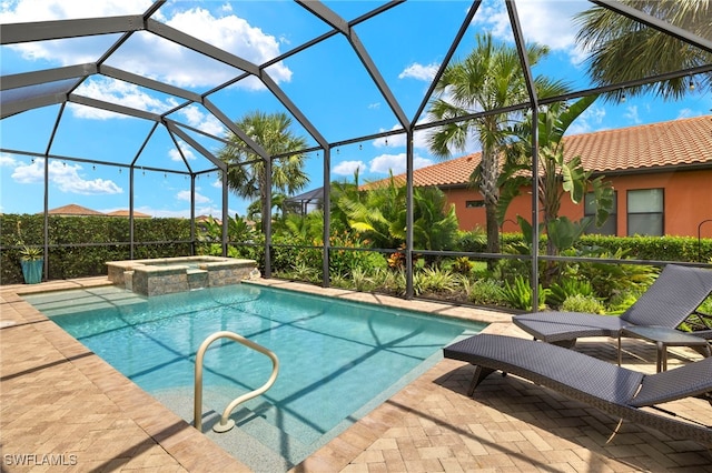 view of swimming pool featuring a lanai, a patio area, and a pool with connected hot tub