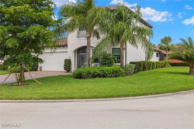 view of front of home with stucco siding, an attached garage, decorative driveway, and a front yard