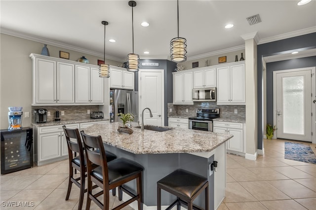 kitchen with appliances with stainless steel finishes, a kitchen island with sink, sink, white cabinetry, and wine cooler