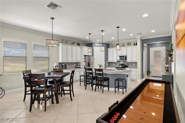 dining space with crown molding, light tile patterned floors, baseboards, and visible vents