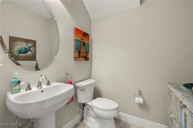 bathroom featuring tile patterned floors, vaulted ceiling, toilet, and sink