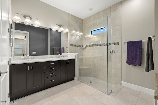 bathroom with ceiling fan, tile patterned flooring, vanity, and tiled shower