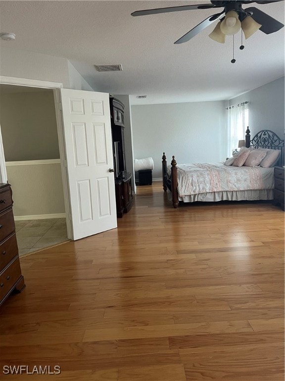 unfurnished bedroom featuring hardwood / wood-style floors, a textured ceiling, and ceiling fan