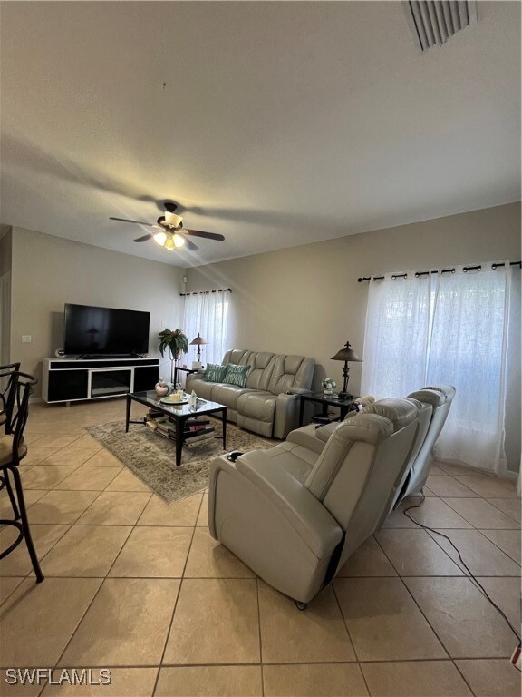 living room featuring light tile patterned floors and ceiling fan