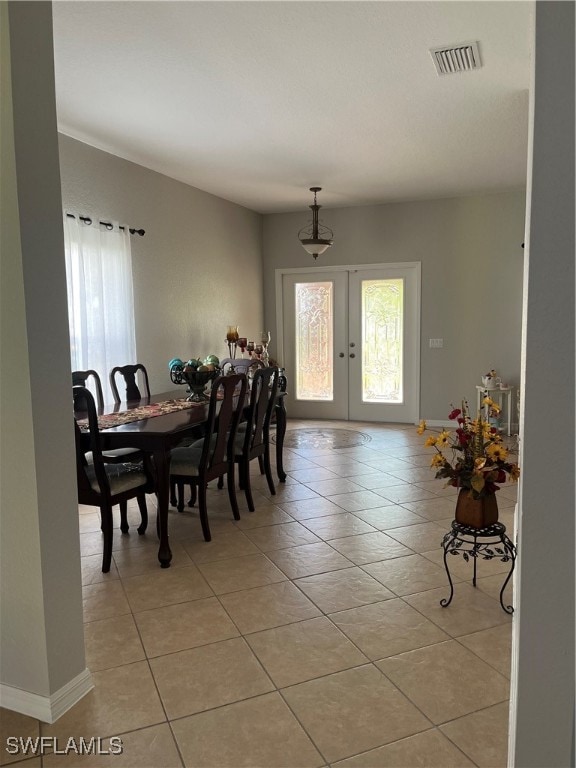 tiled dining area featuring french doors